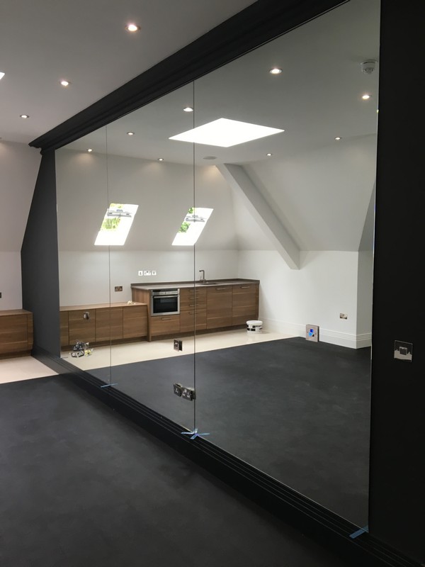 Frameless glass partition in loft conversion by Wembley glaziers